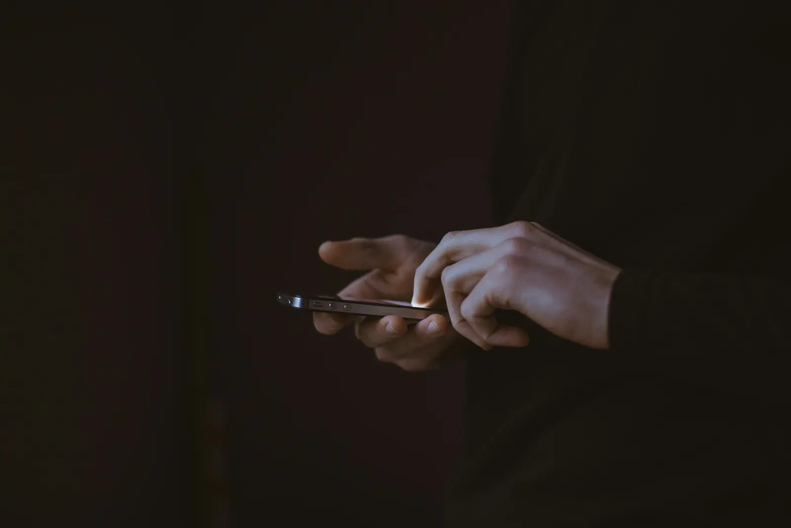 Hand holding a phone in the dark