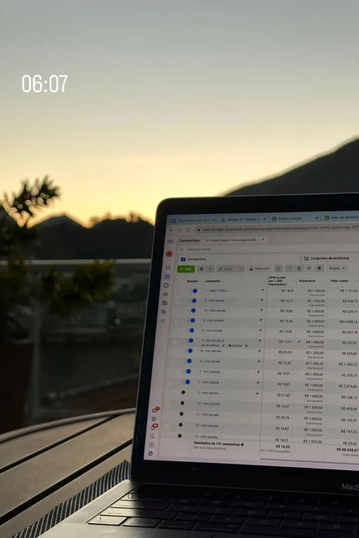 A laptop with a Shopify orders list at sunset